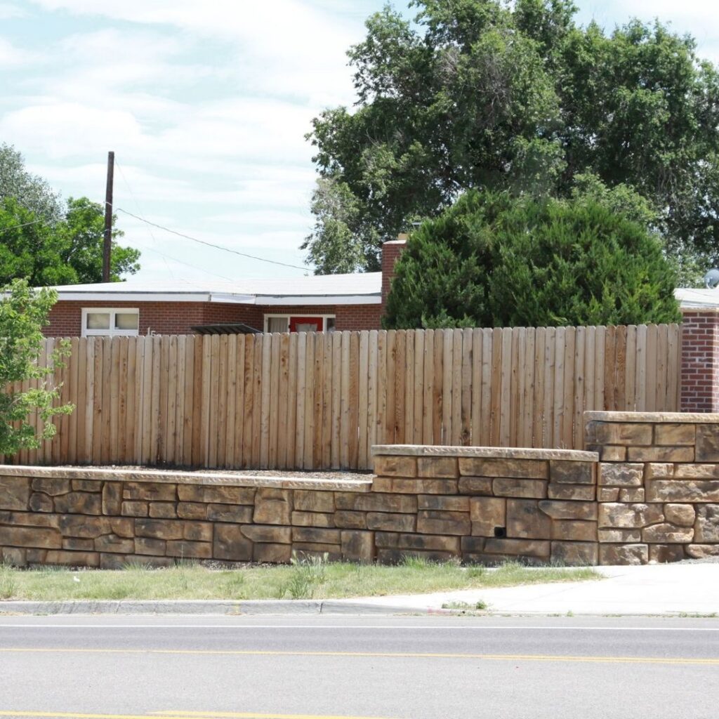 a retaining wall in front of a fence